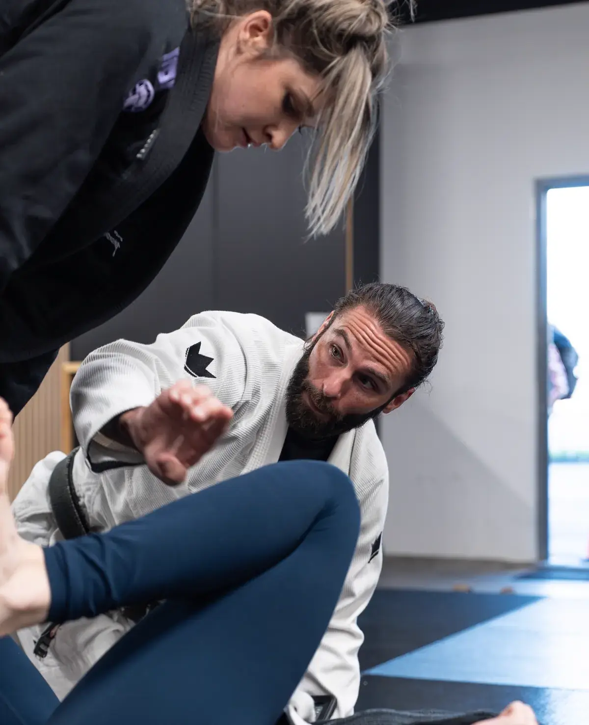 A Logic black belt coach correcting technique with beginner students in the white-belt-only class in Fishtown