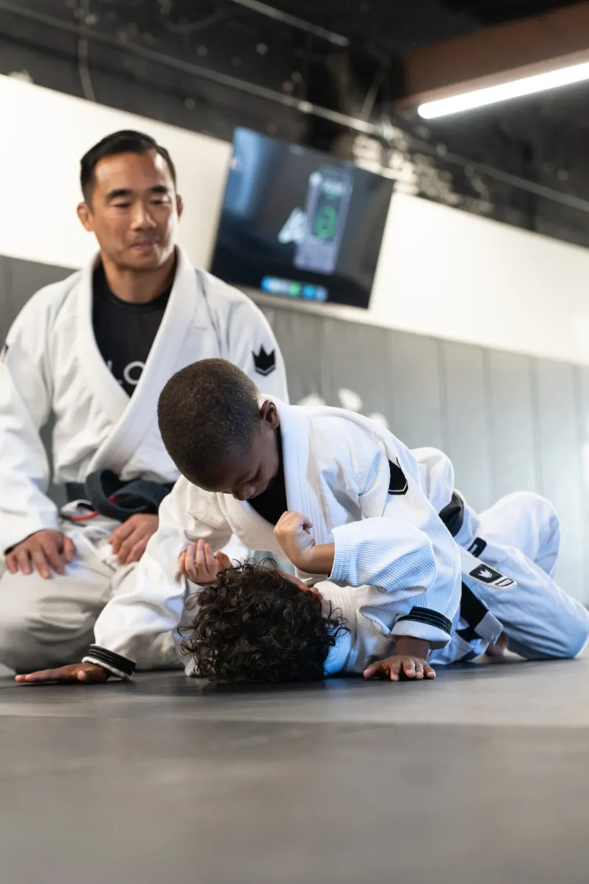 Young student drilling the mount position under the direct supervision of Coach Matt