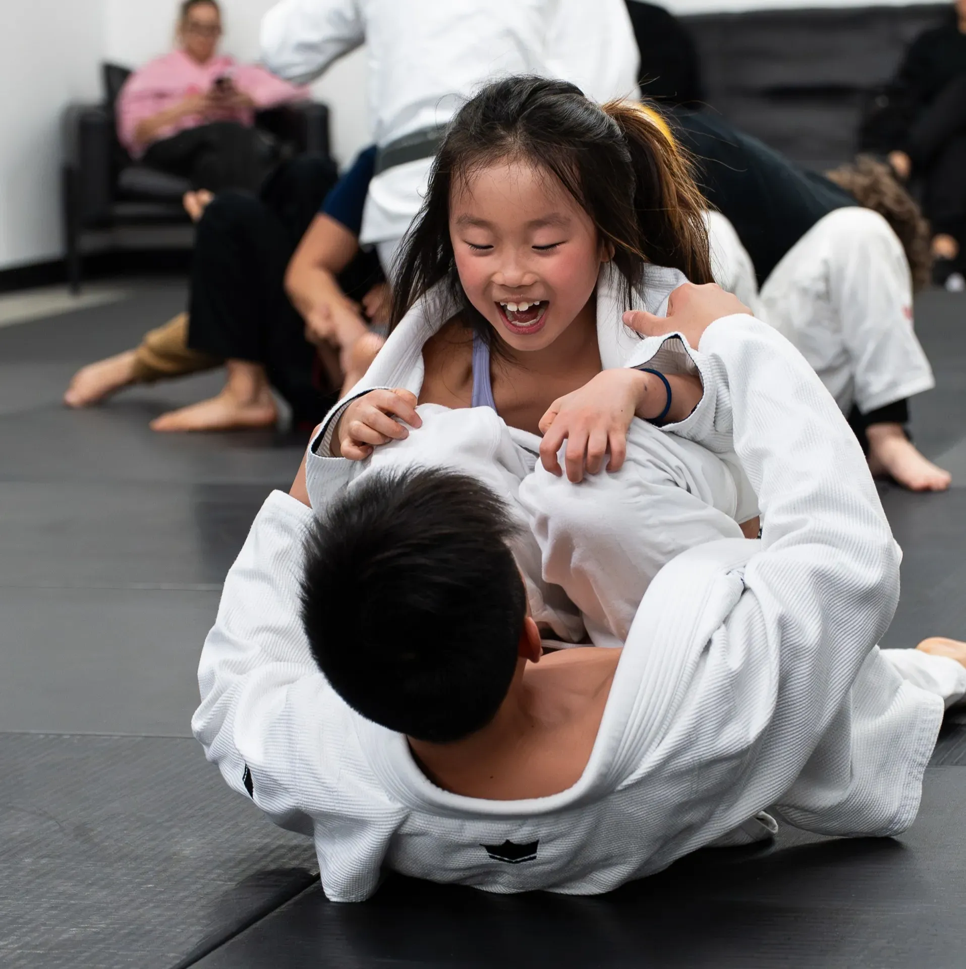 Kids Jiu Jitsu class — student drilling with coach