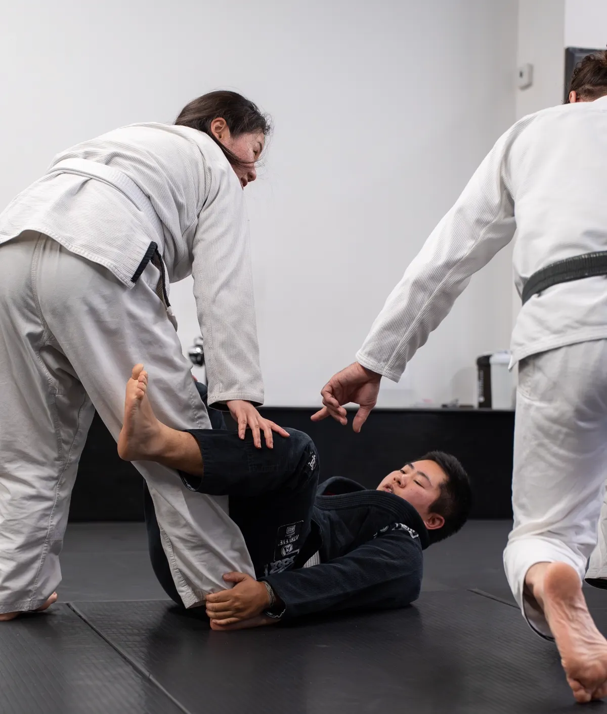 White belt drilling a position with a partner under coach supervision at Logic Philadelphia